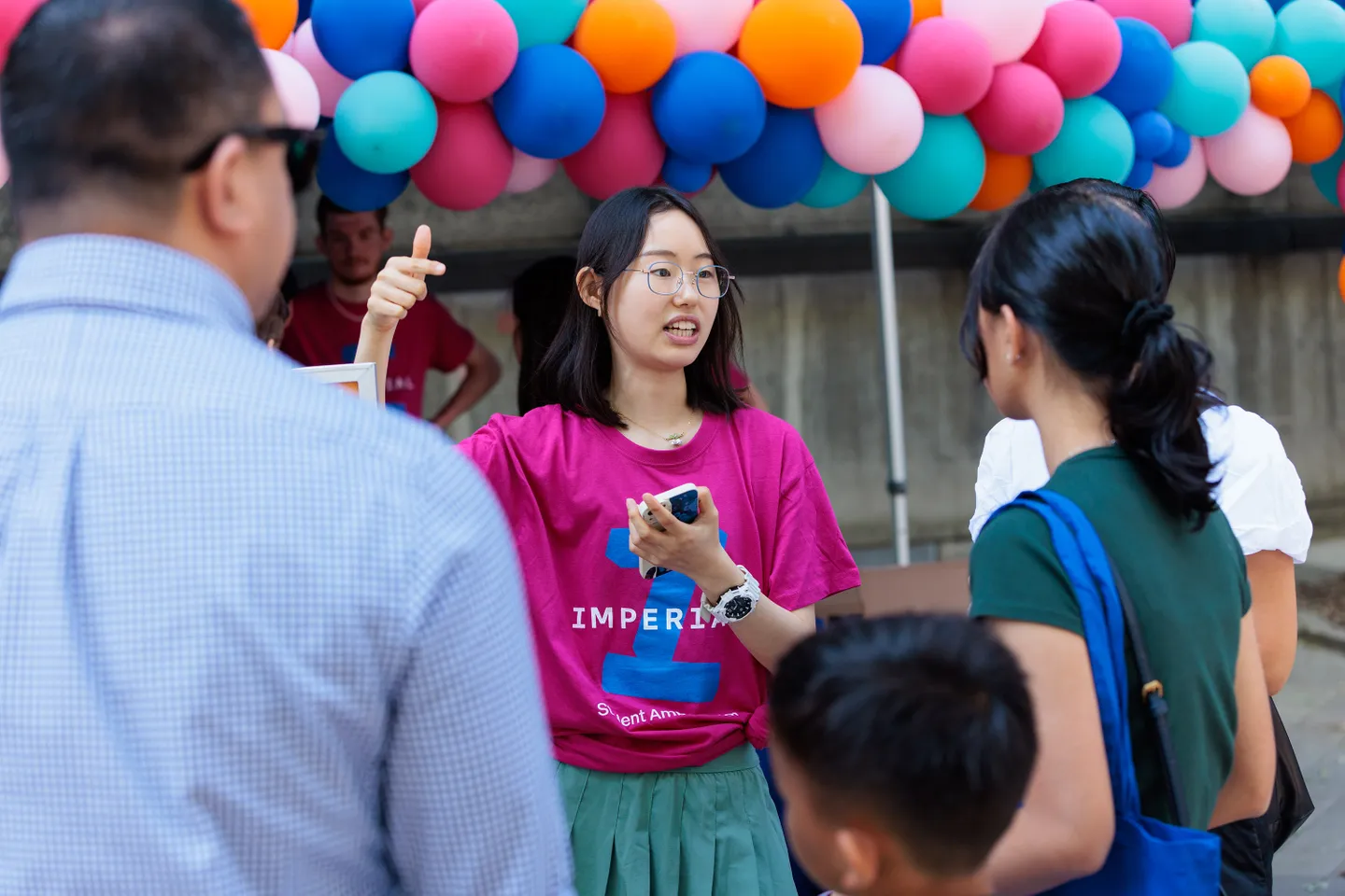 A student ambassador in a pink t-shirt talking to visitors at Imperial's Open Days