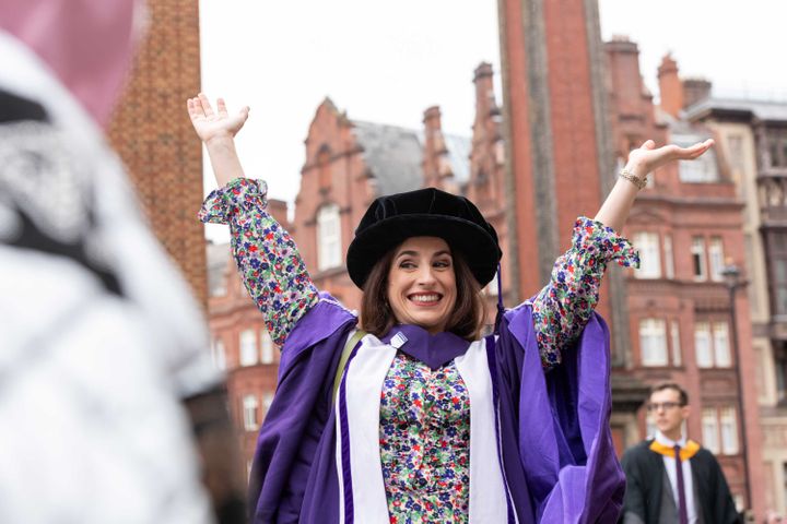 A PhD graduate celebrates after her ceremony outside the Royal Albert Hall.
